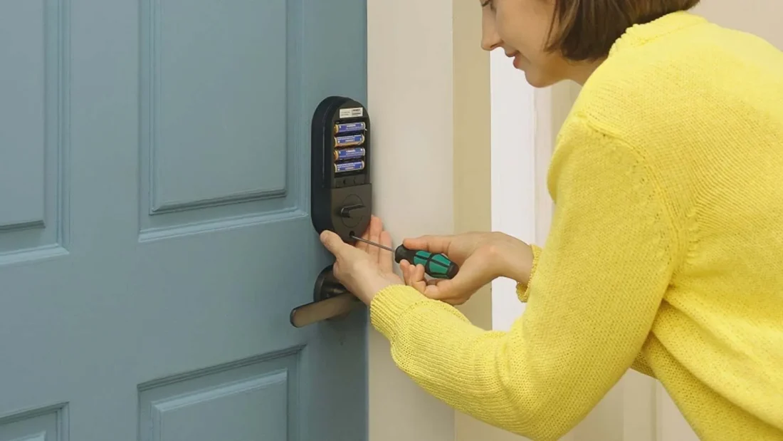 Mujer cambiando pilas de cerradura inteligente