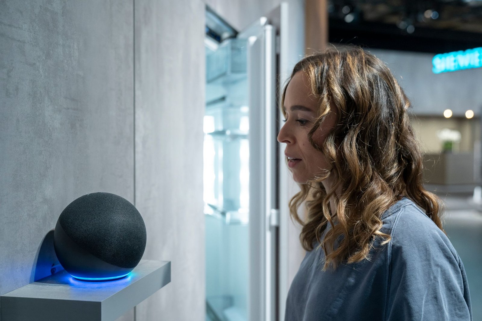 Persona usando comandos de voz para conectar Alexa a la TV en un salón moderno